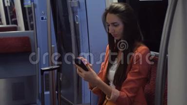 一个穿西装的年轻女子坐火车回家时在智能手机上发短信
